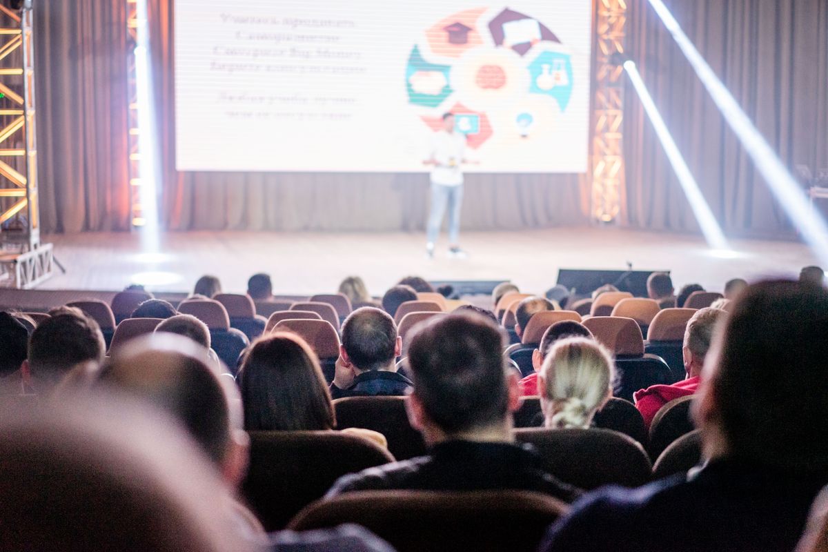 Illustrative photograph of an audience watching a conference speaker.