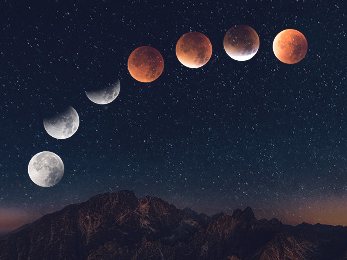 A sequence of lunar eclipse phases forms an arc across a star-filled sky above dark mountain peaks.